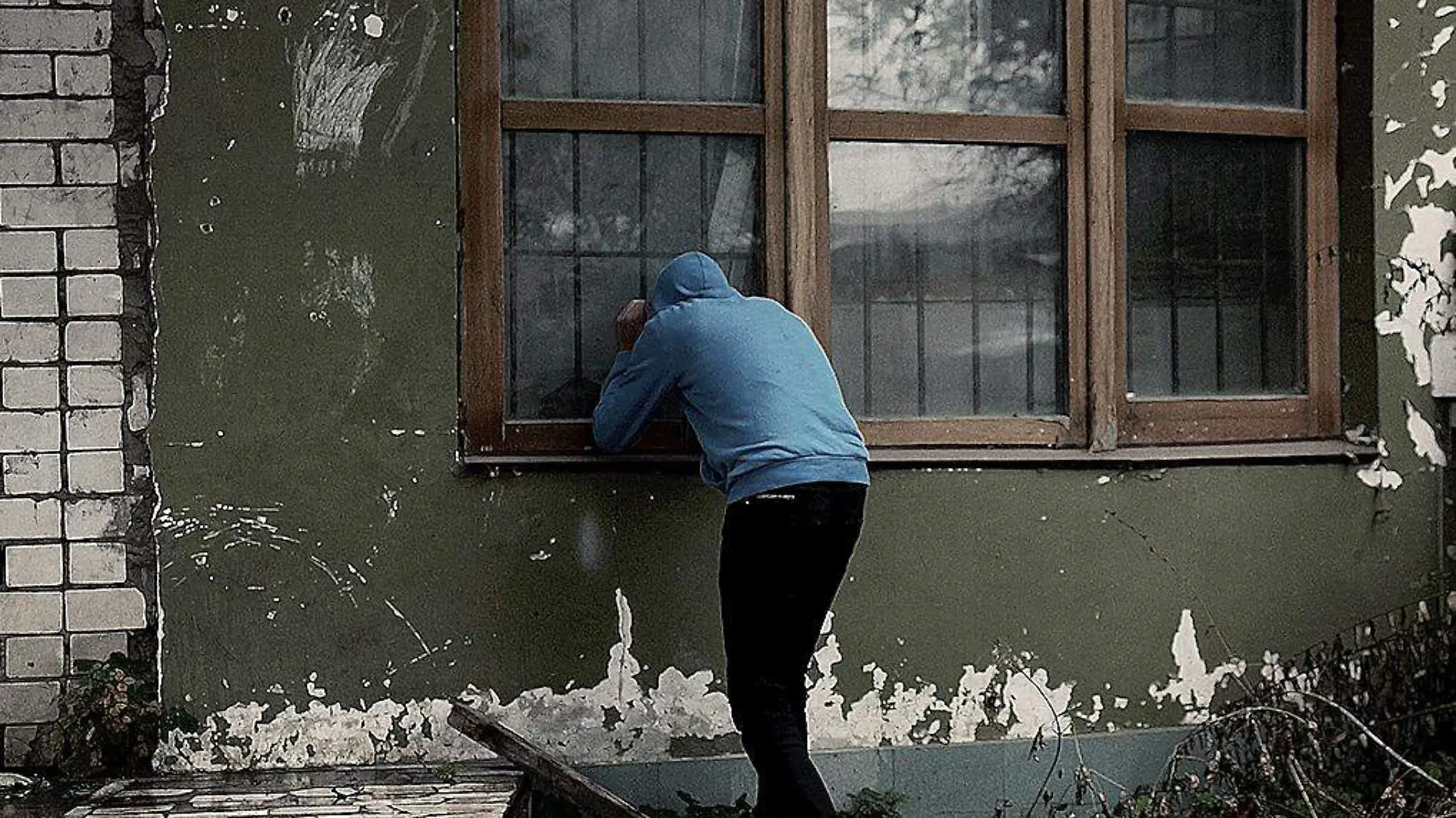 Hombre mirando por la ventana de una habitación